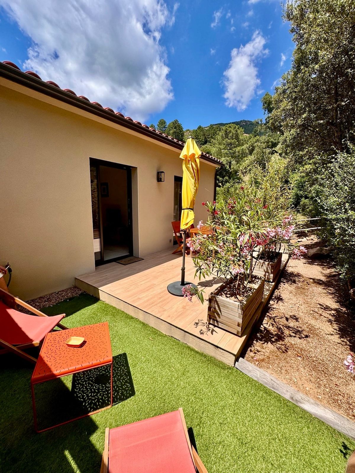 Private garden with deckchairs, terrace and the mini-villa’s façade