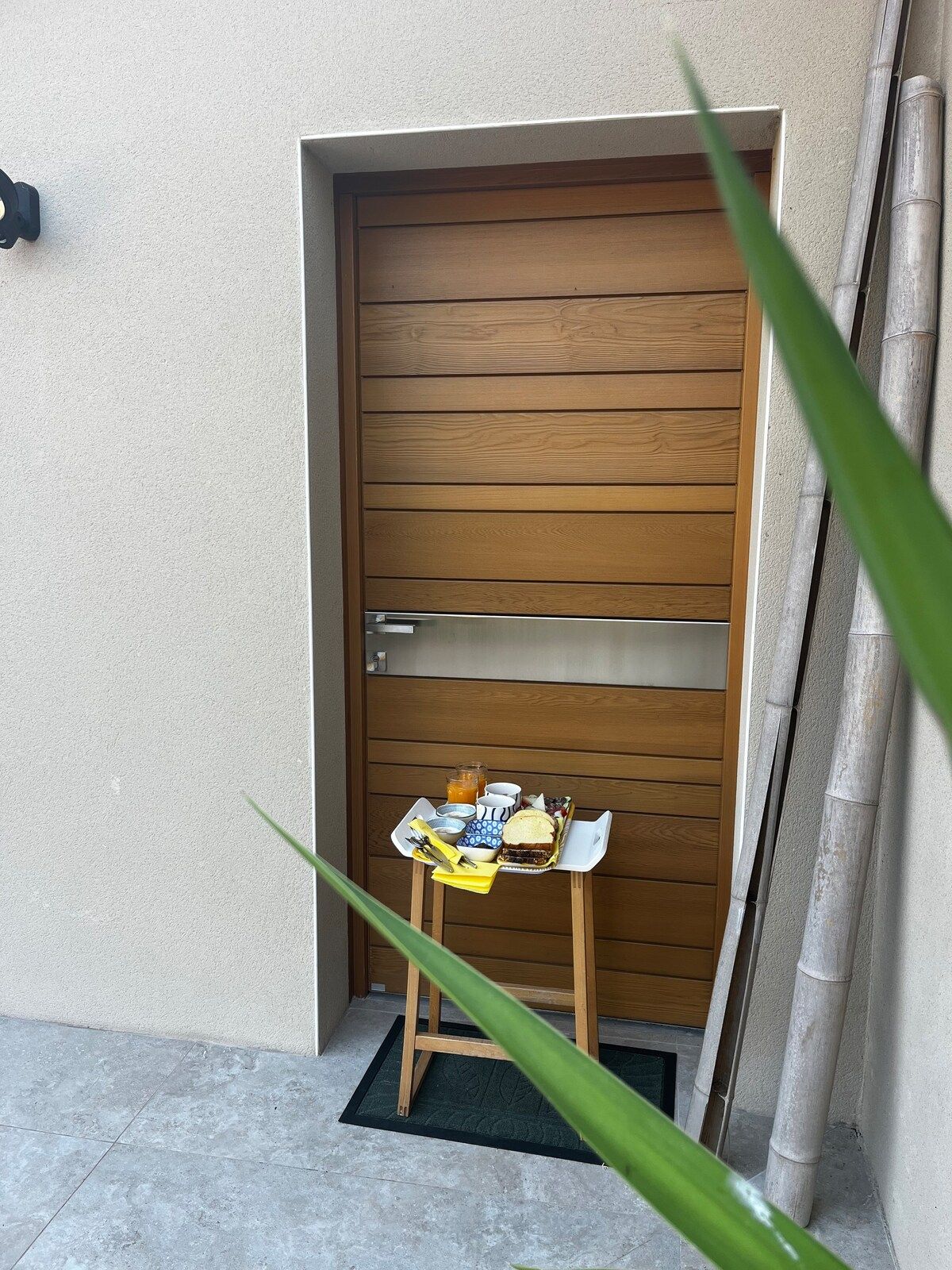 Plateau du petit-déjeuner déposé devant la porte en bois de la suite