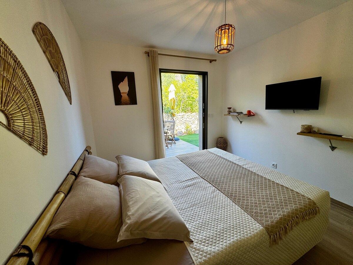 Bright bedroom with a natural-toned bed and a French window onto the garden