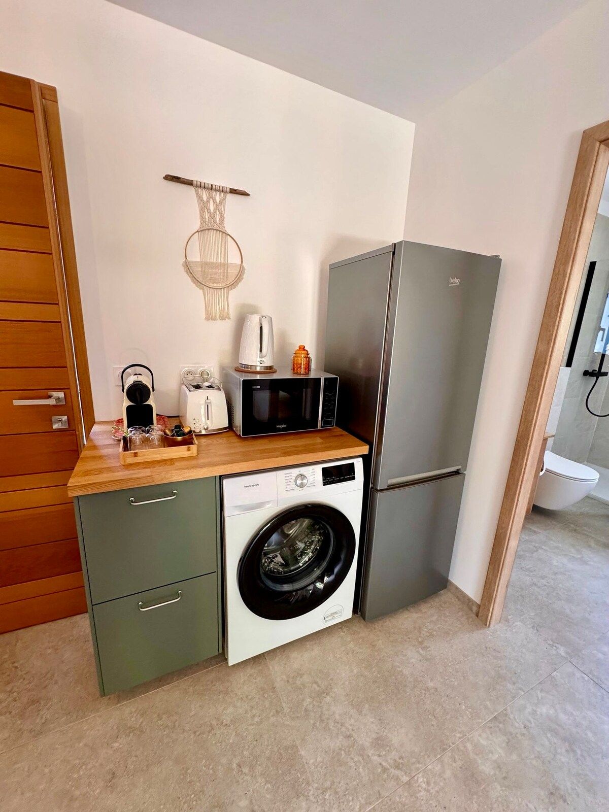 Fridge, washing machine and coffee corner in the kitchen