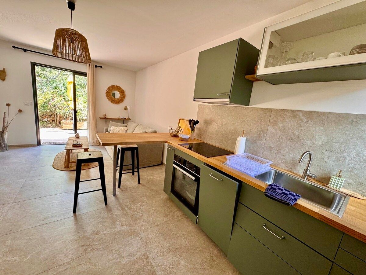 Fully equipped kitchen with wooden worktop and sage-green units