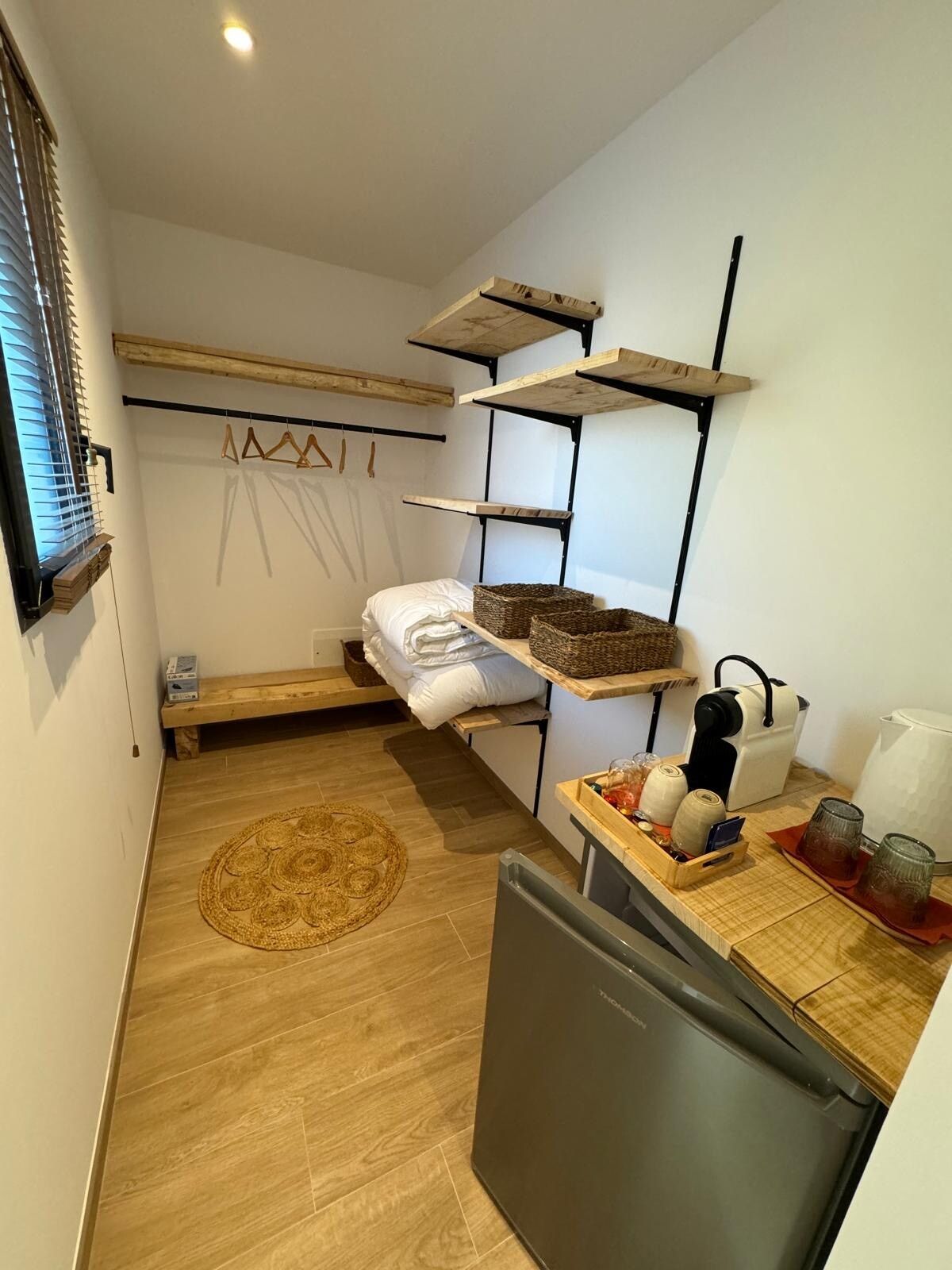 Dressing ouvert avec étagères, linge de toilette et coin café