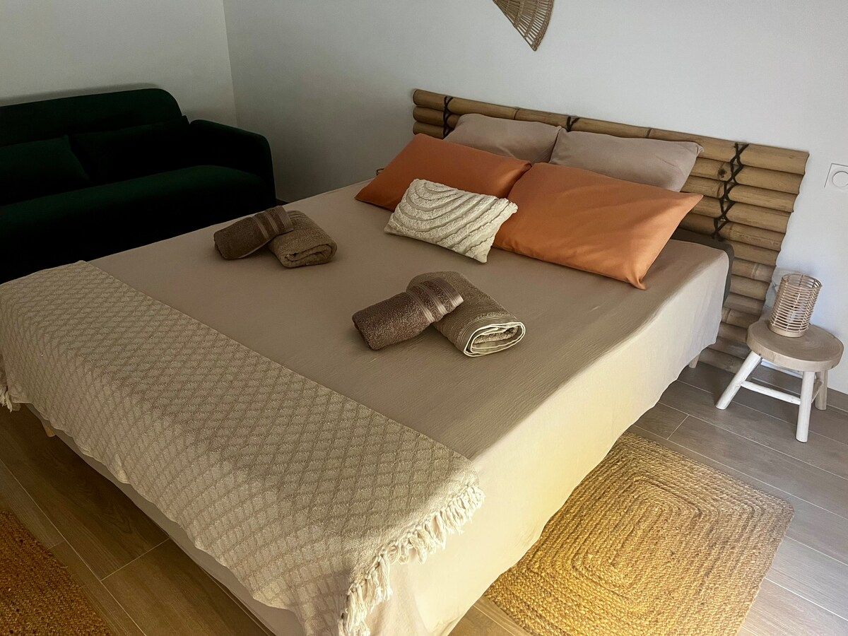 Lit fait avec serviettes pliées, coussins terracotta