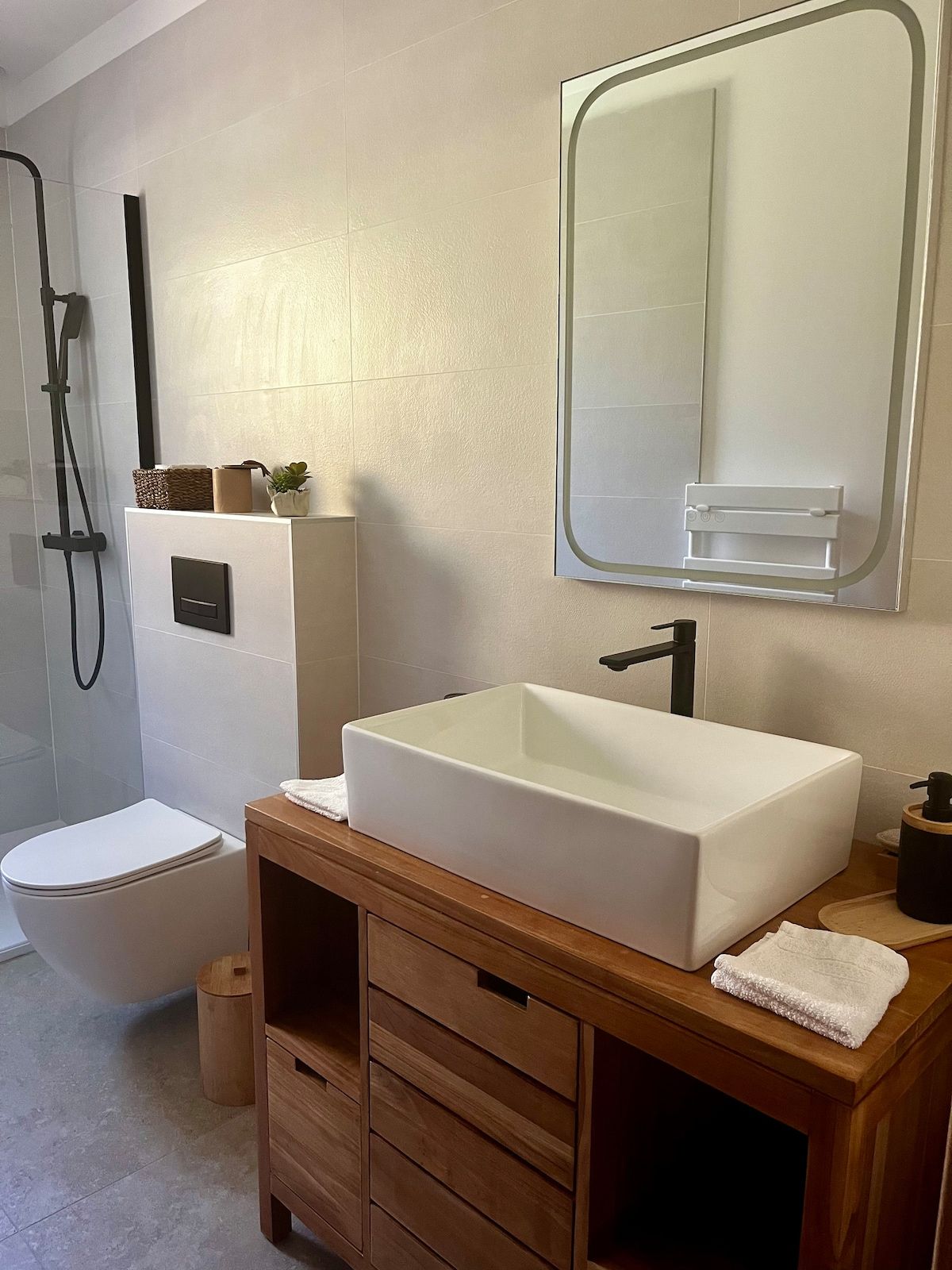 Salle de douche avec WC suspendus et miroir lumineux